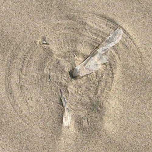 Plastic tussen je tenen op het strand